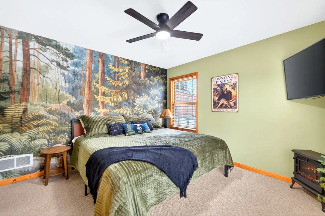 Bedroom with a painted forest mural and a gas fireplace