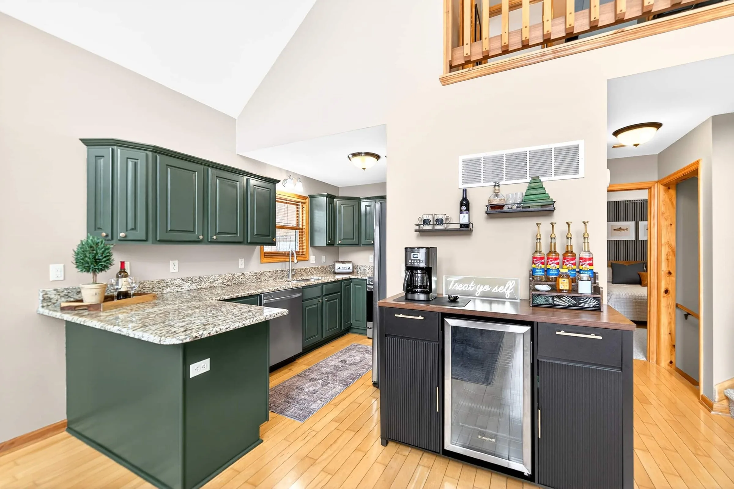 Kitchen with green cabinets, granite counters and the coffee bar