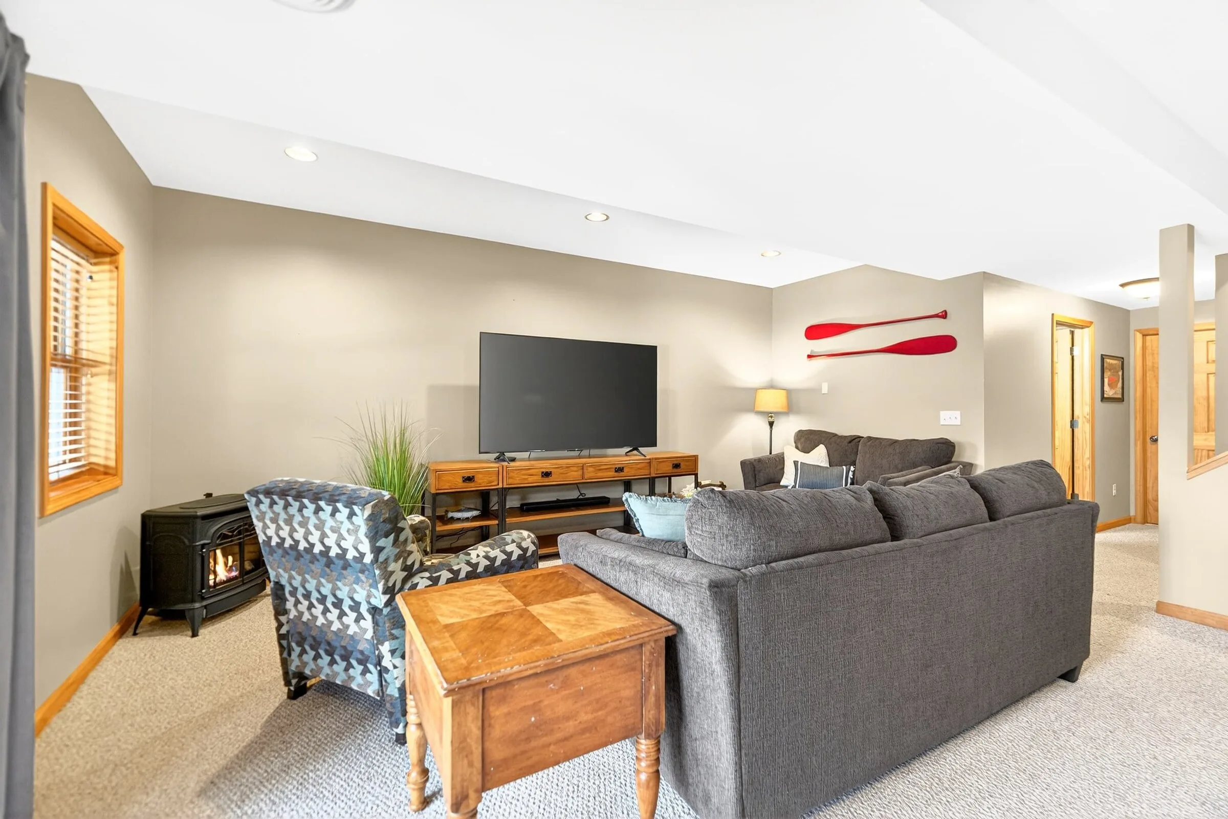 Lower level movie room with a sectional and a gas fireplace