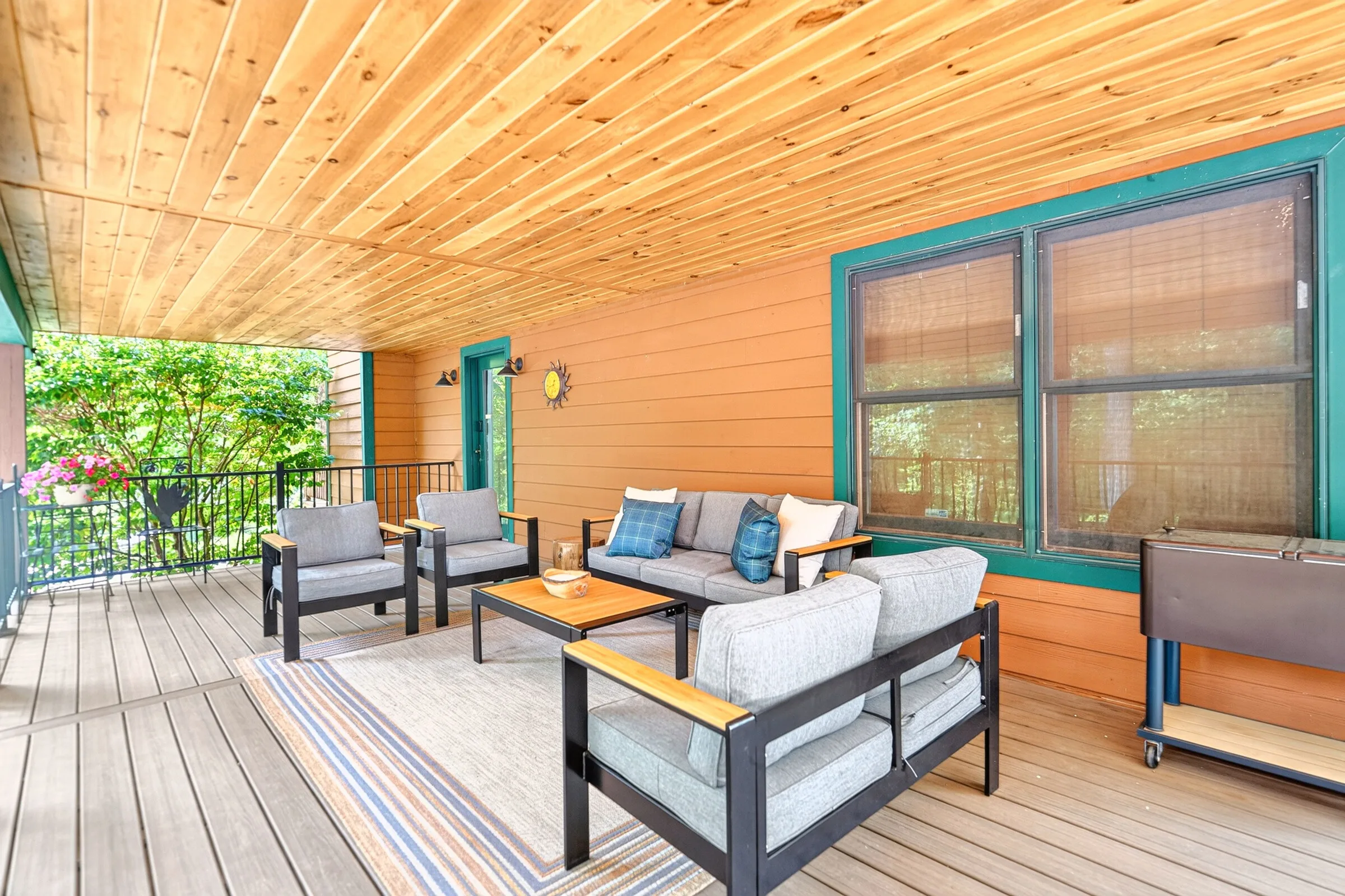 The covered deck furnished with sofas and a low table