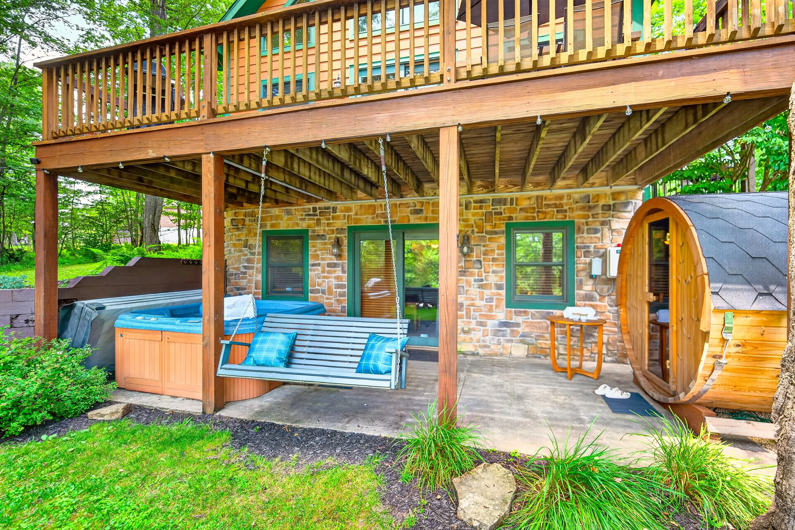 Hot tub, porch swing and the cedar barrel sauna under the deck